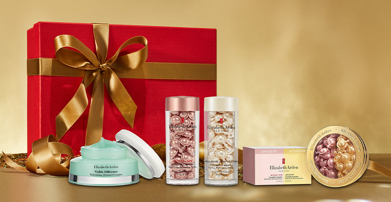 Red gift box with gold ribbon on a beige-gold background featured with Elizabeth Arden skincare products. 