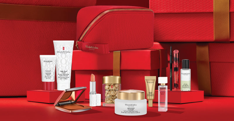 Collection of Elizabeth Arden skincare and makeup products with beauty bag on a red background