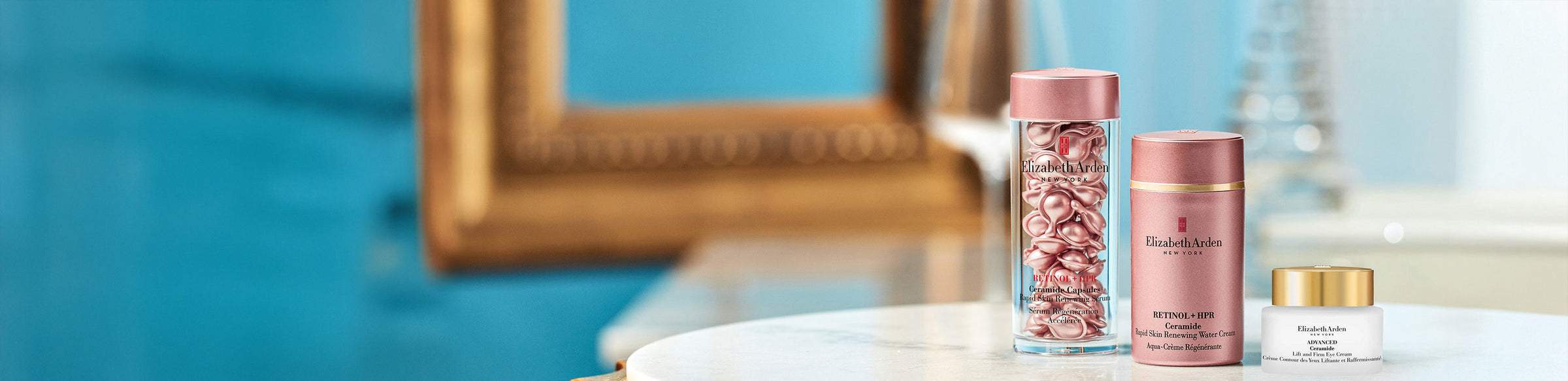 Elizabeth Arden skin care products on a marble table top with gold mirror in the background on a blue blue background