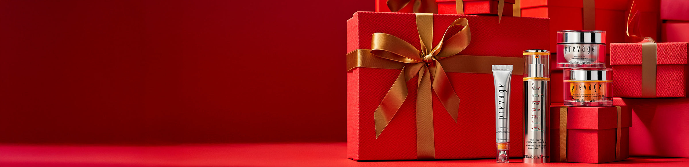 Elizabeth Arden skin care products standing in front of red gift boxes with gold ribbons on a red surface