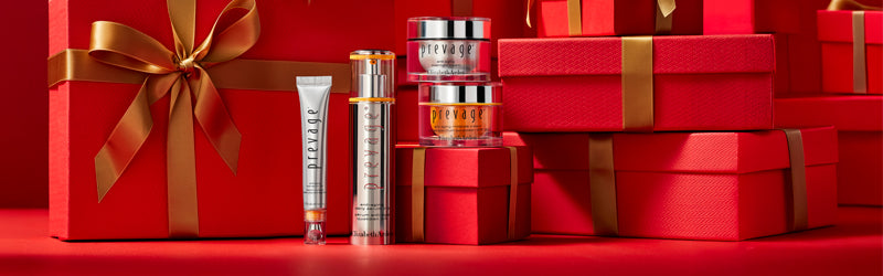 Elizabeth Arden skin care products standing in front of red gift boxes with gold ribbons on a red surface