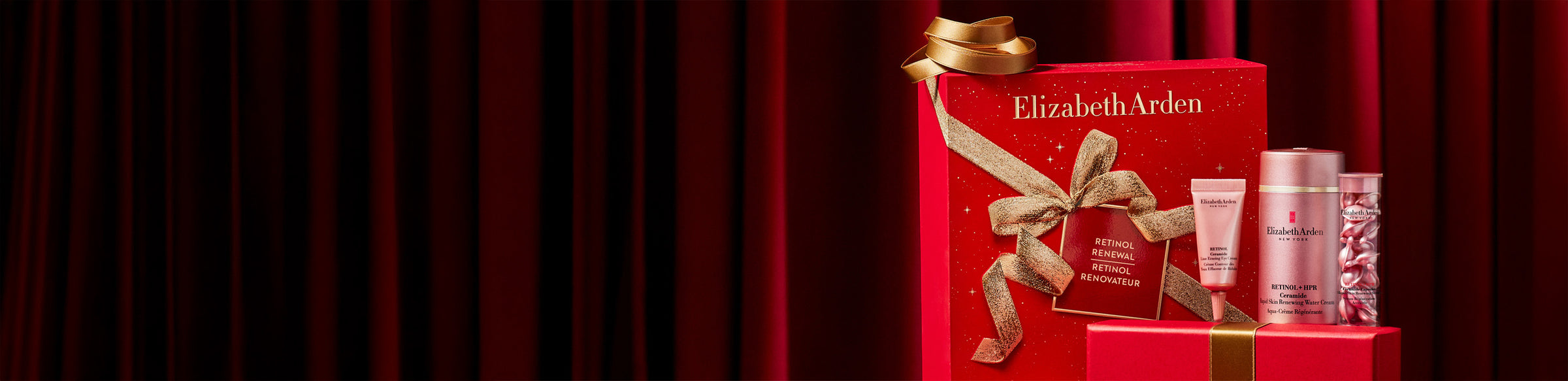 Elizabeth Arden beauty product set with a red box on a dark red curtain background
