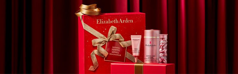 Elizabeth Arden beauty product set with a red box on a dark red curtain background
