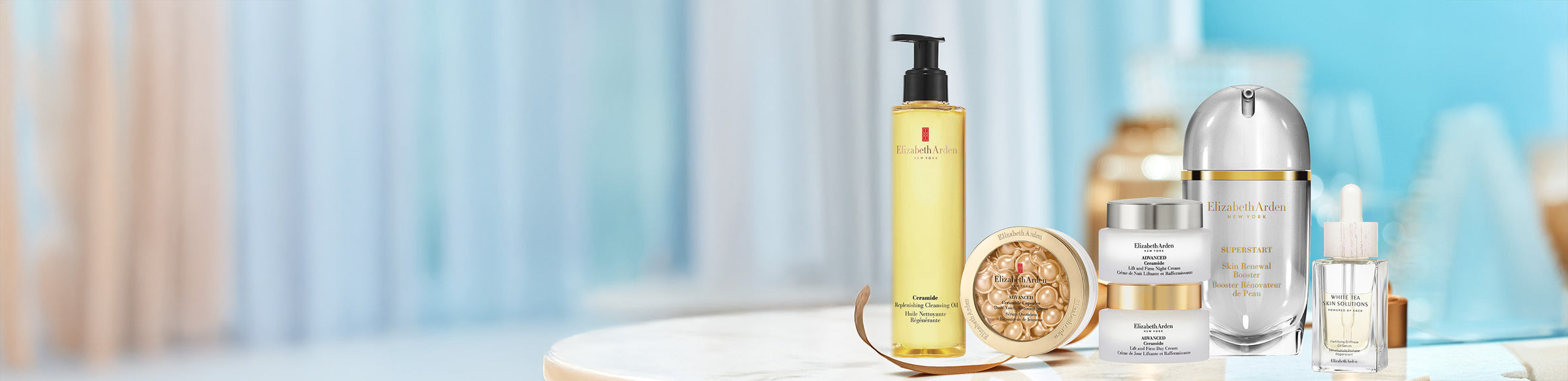 Collection of Elizabeth Arden skincare products on a marble tabletop with a blurred blue background