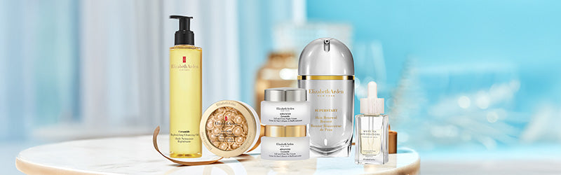 Collection of Elizabeth Arden skincare products on a marble tabletop with a blurred blue background