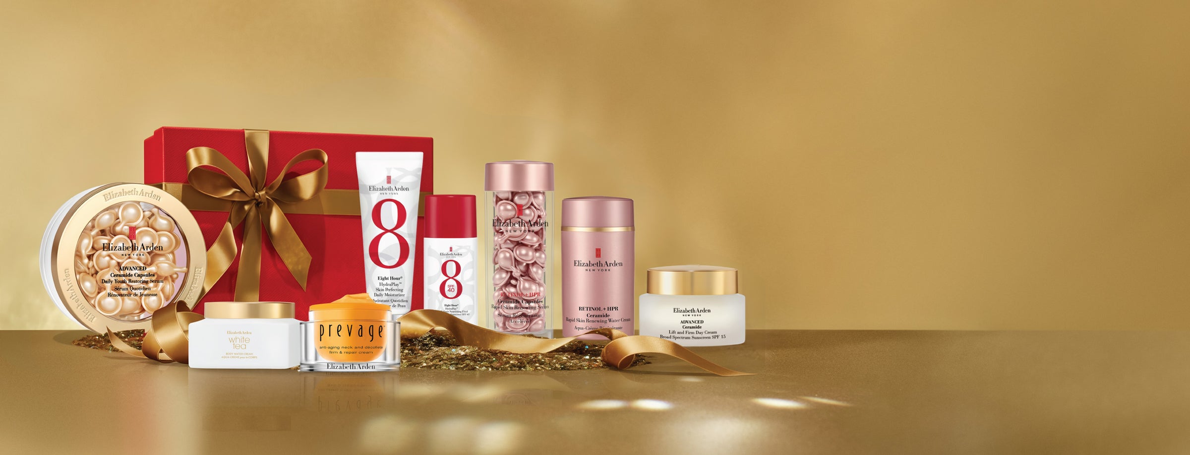 Set of skincare products with a red gift box on a gold background