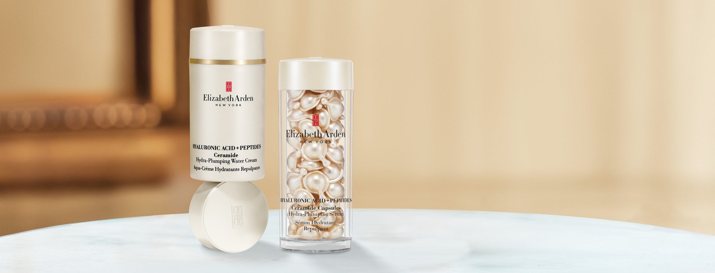Collection of Elizabeth Arden Hyaluronic Acid + Peptides skincare products on a blurred beige background