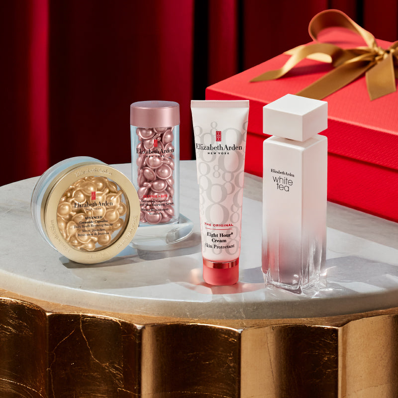 Elizabeth Arden beauty products on a marble surface with a red gift box in the background.