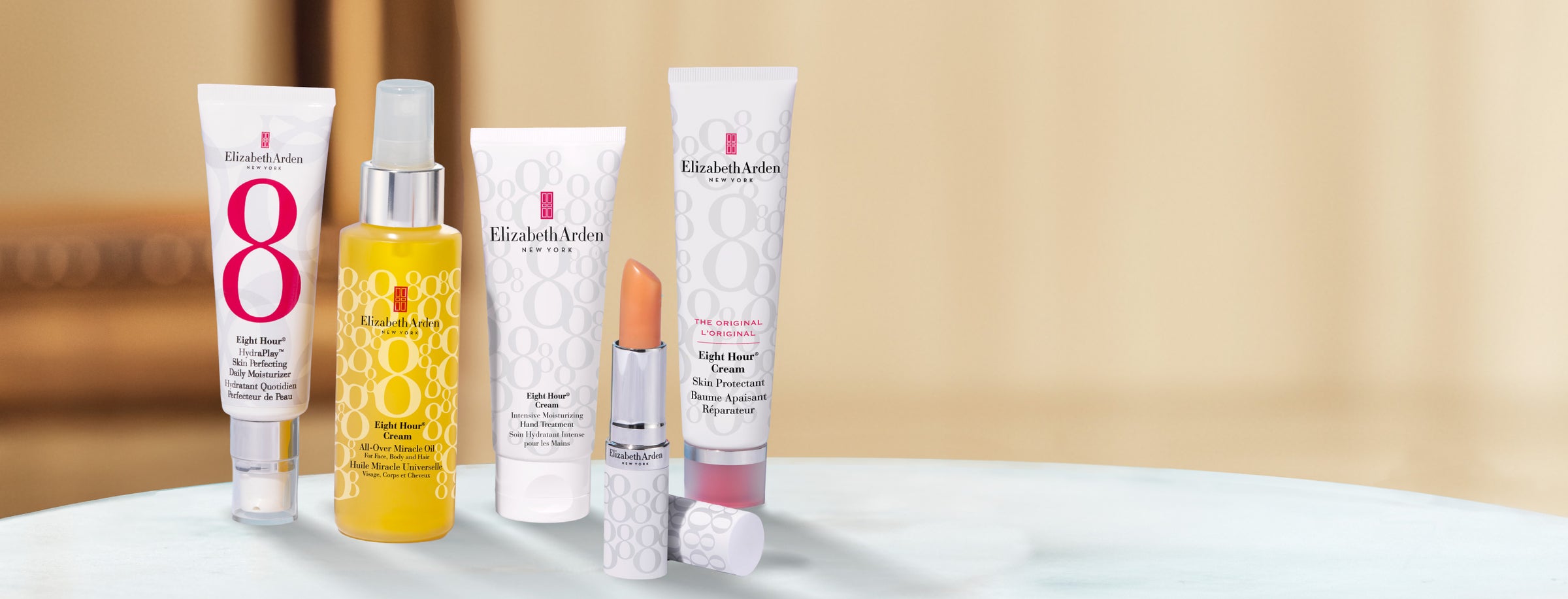 Collection of Elizabeth Arden Eight Hour skincare and lip care products on a blurred beige background