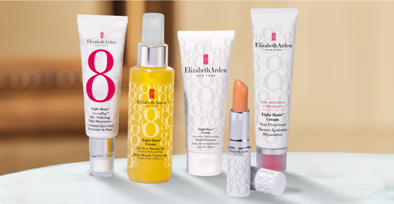Collection of Elizabeth Arden Eight Hour skincare and lip care products on a blurred beige background