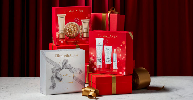 Elizabeth Arden gift set with red boxes and skincare products on a red curtain background