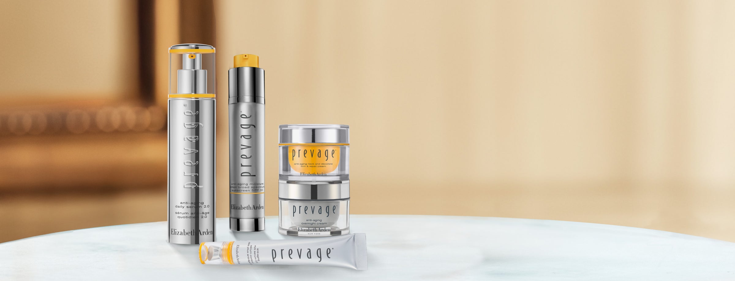 Collection of Elizabeth Arden Prevage skincare products on a blurred beige background