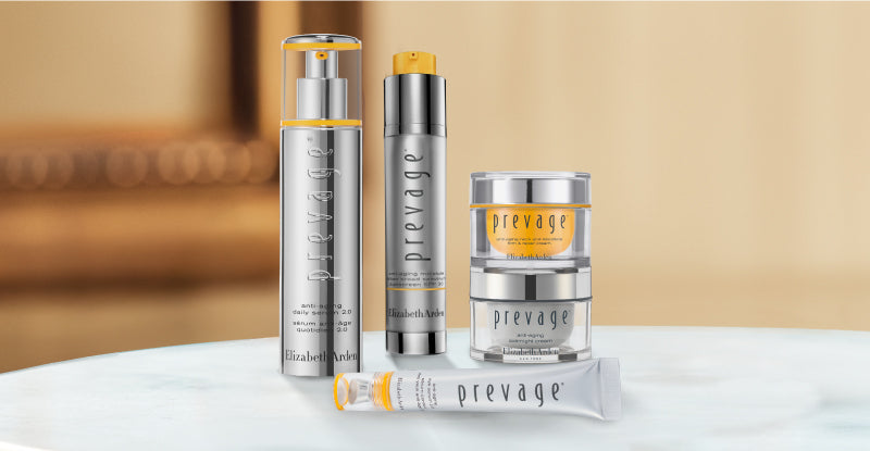Collection of Elizabeth Arden Prevage skincare products on a blurred beige background