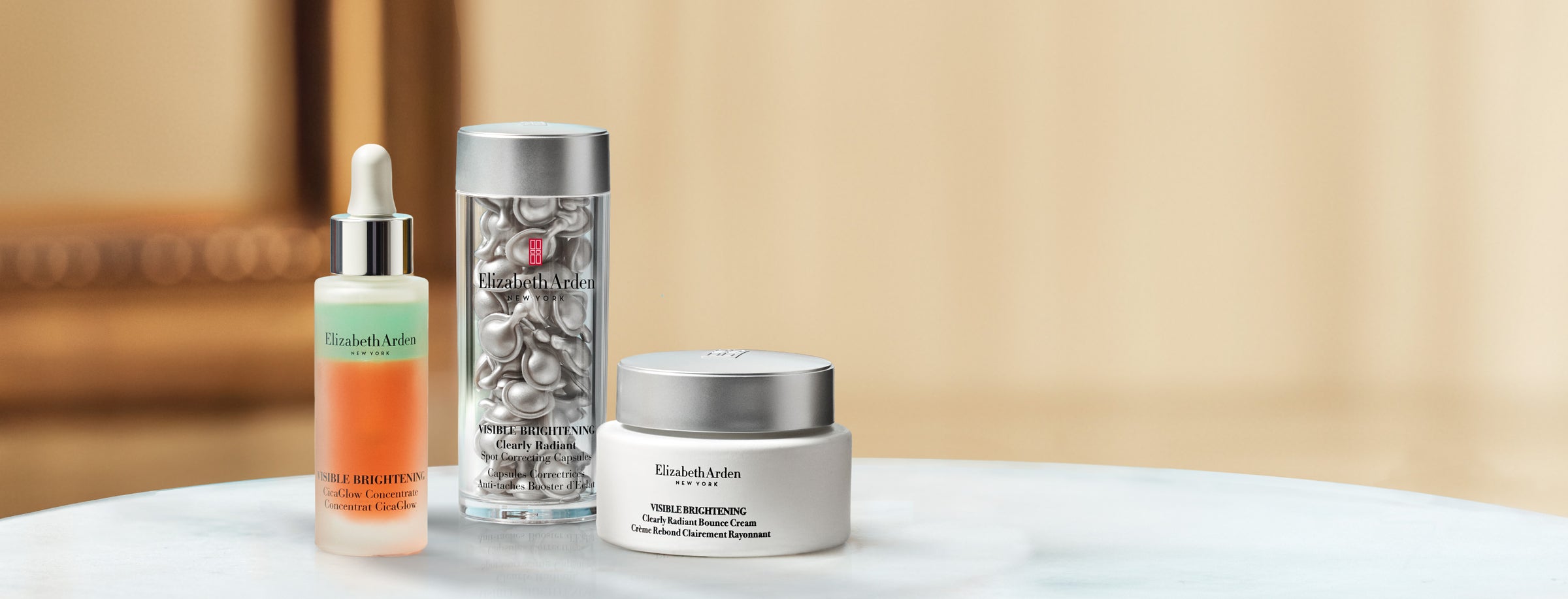 Collection of Elizabeth Arden Visible Brightening skincare products on a blurred beige background