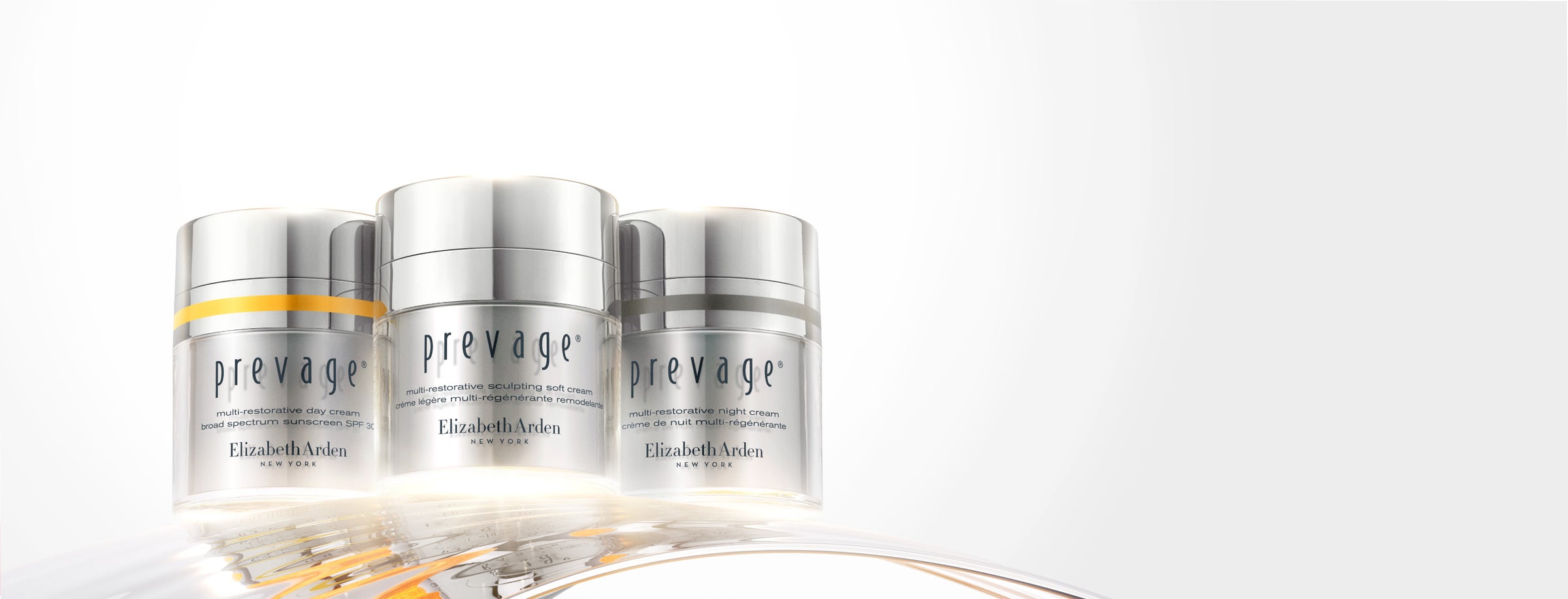 Three silver 'prevage' skincare jars on a white background