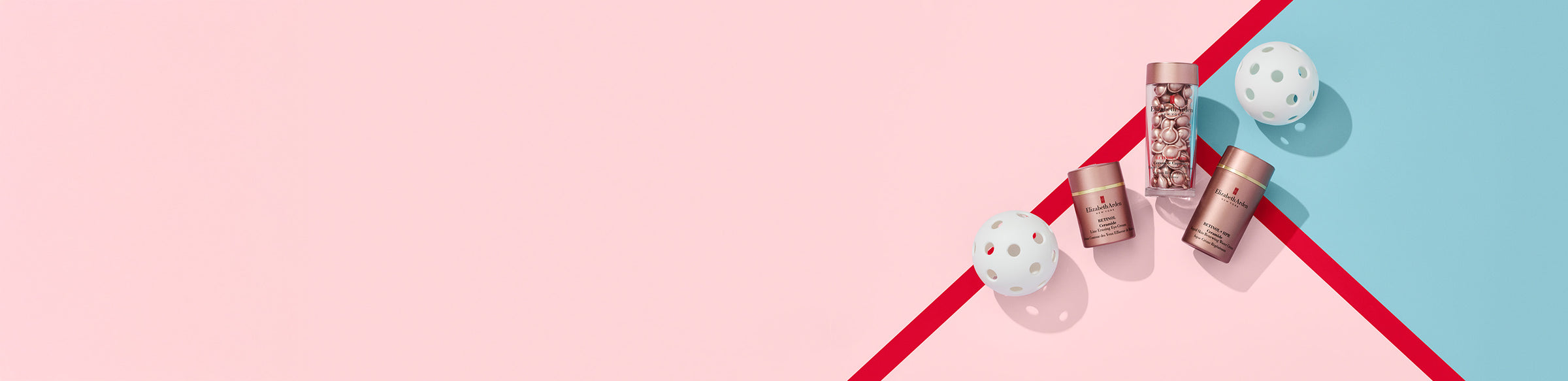 Collection of Elizabeth Arden Retinol products on a pink and blue background with red lines, next to 2 pickleball balls.