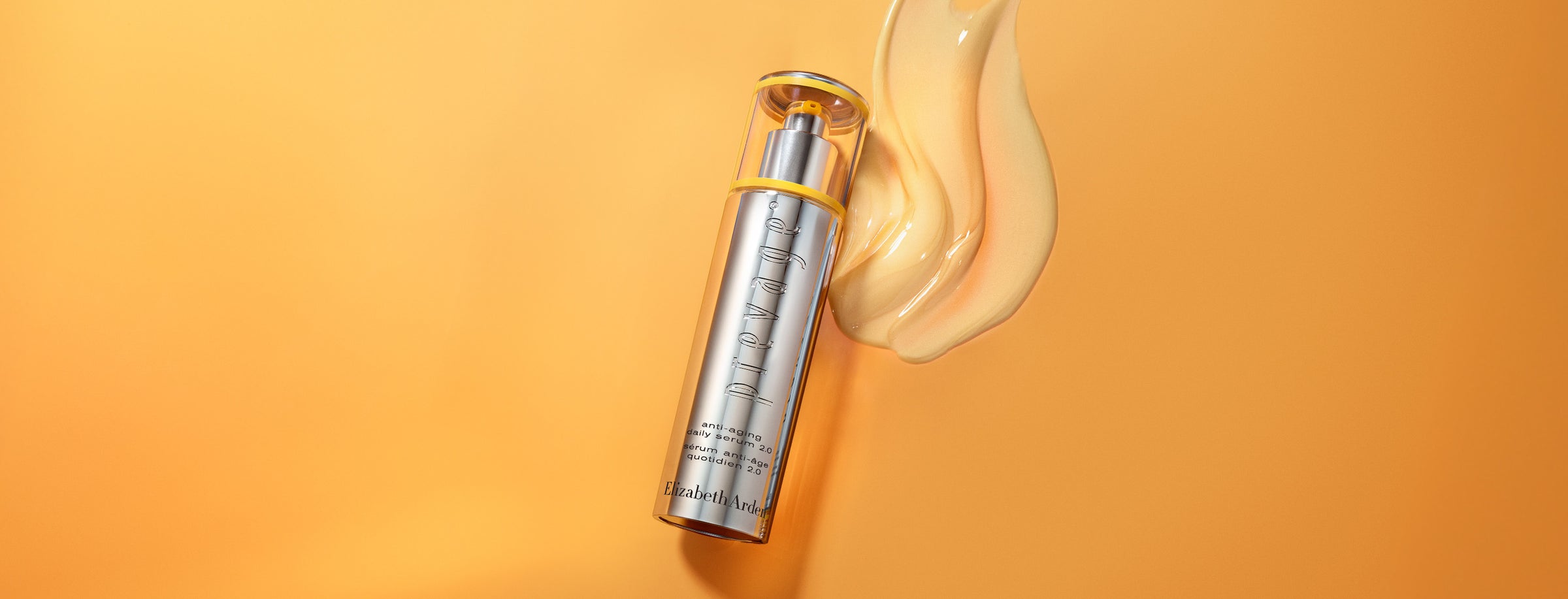 Skincare serum bottle with a droplet of product on an orange background