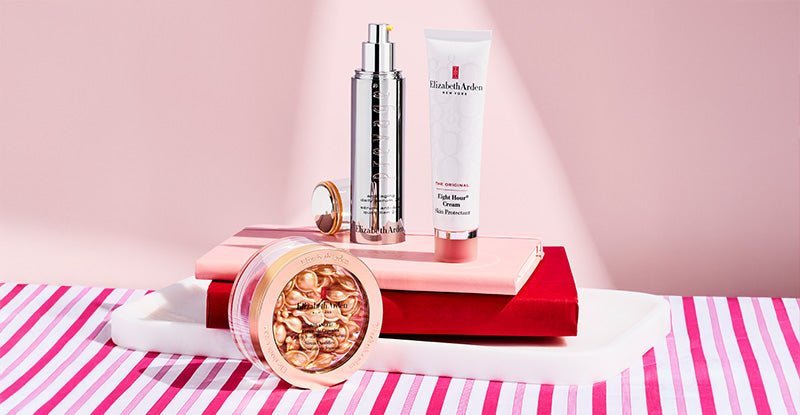 Elizabeth Arden skin care products on a striped towel with a pink background