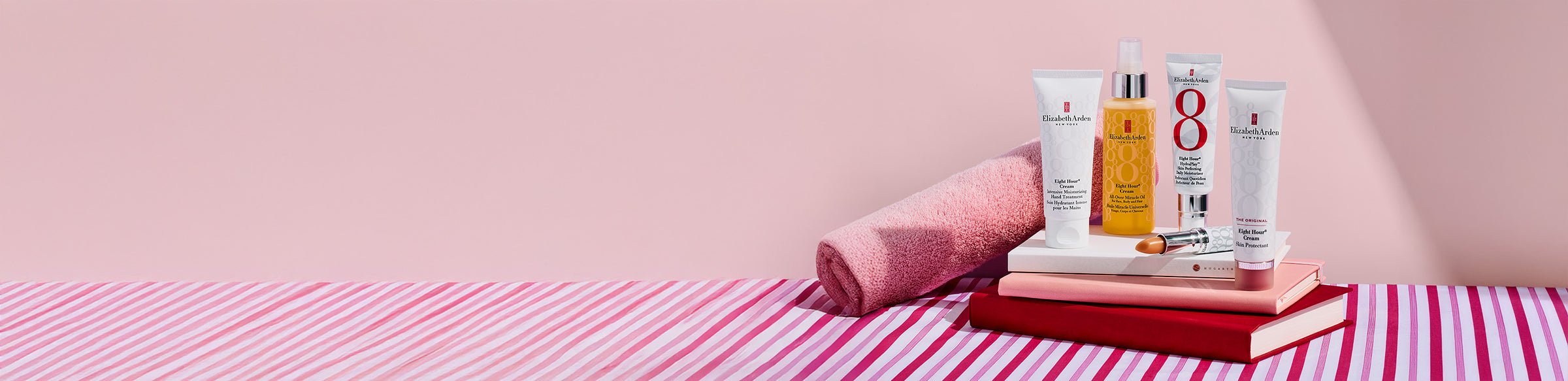 Elizabeth Arden Eight Hour products on a striped towel with a pink background