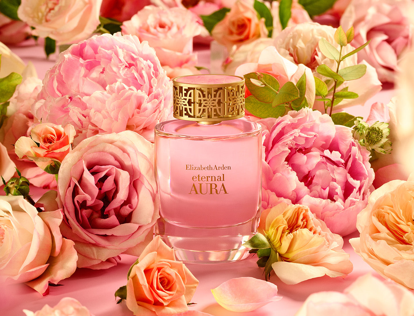 Pink Elizabeth Arden Eternal Aura perfume bottle surrounded by pink flowers