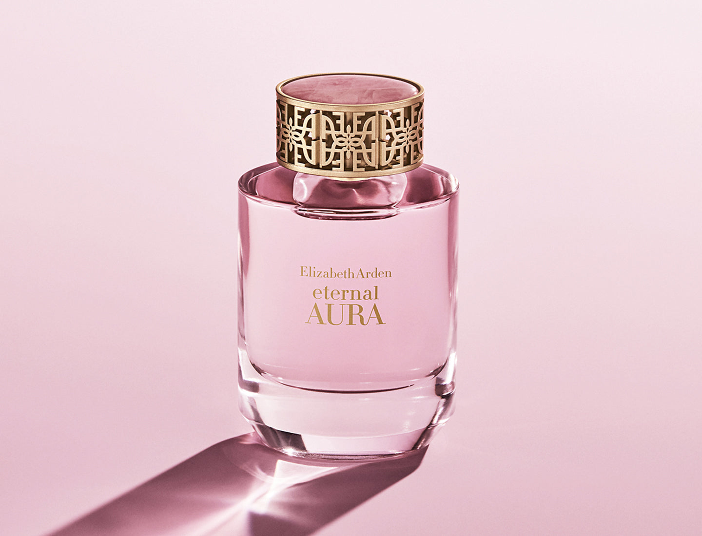 Pink Elizabeth Arden Eternal Aura perfume bottle on a pink background