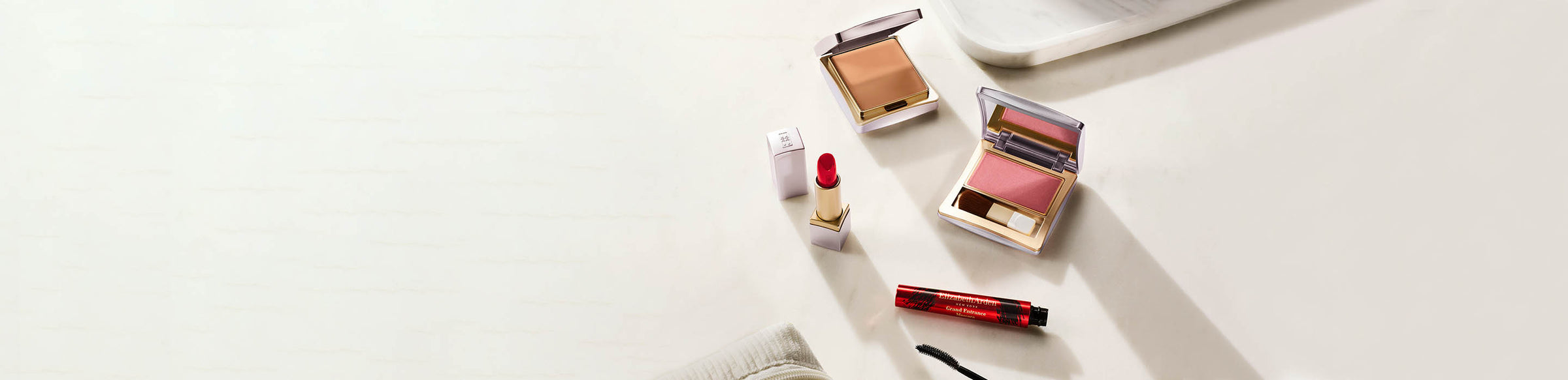 Makeup products including blushes and a lip balm on a white surface