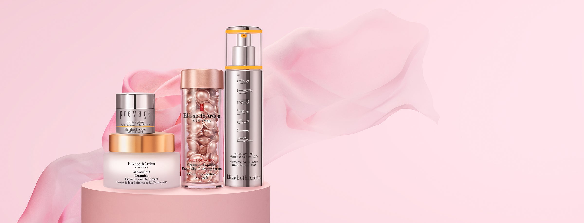 Set of skincare products on a pink platform with a soft pink background