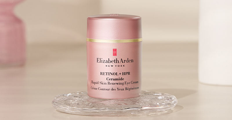 Elizabeth Arden Retinol + HPR Ceramide Eye Cream sitting on a clear tray on a beige background.