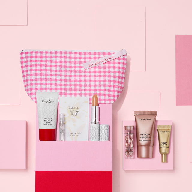 7-piece gift with purchase featuring 6 beauty products and a cosmetic bag on a pink wall