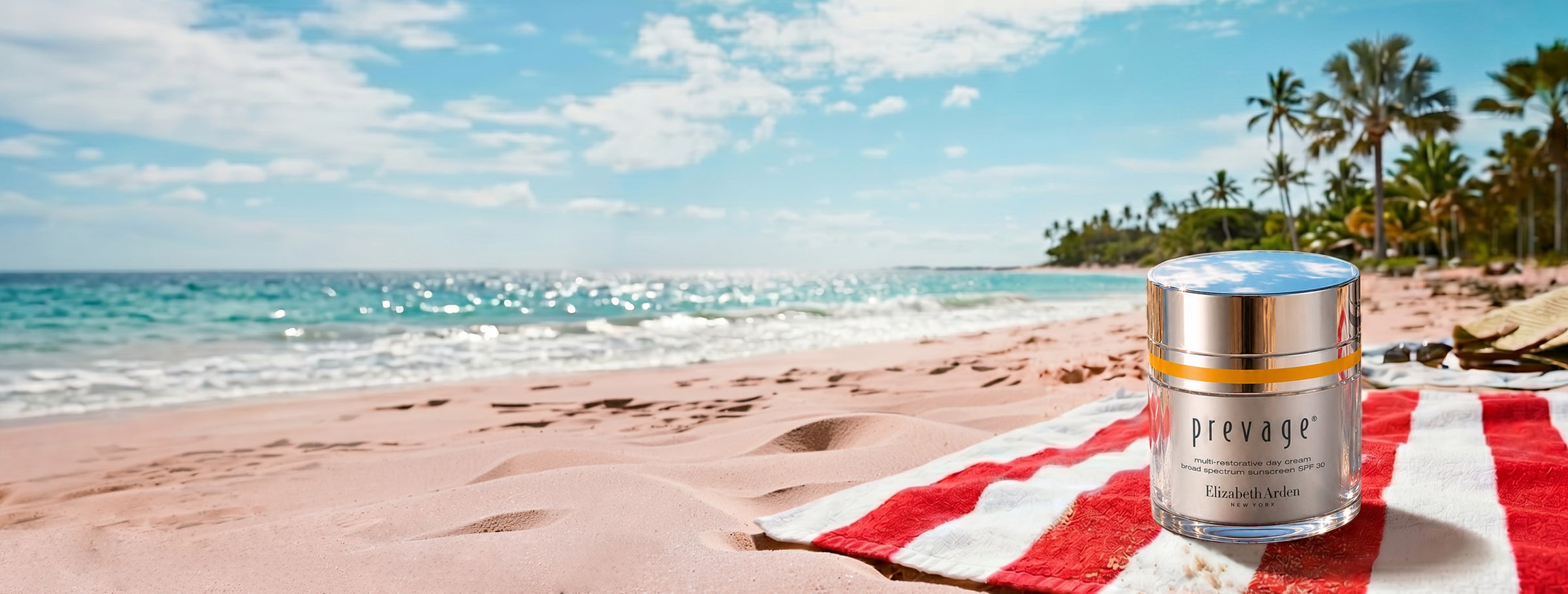 Prevage skincare product on a beach with ocean and palm trees in the background