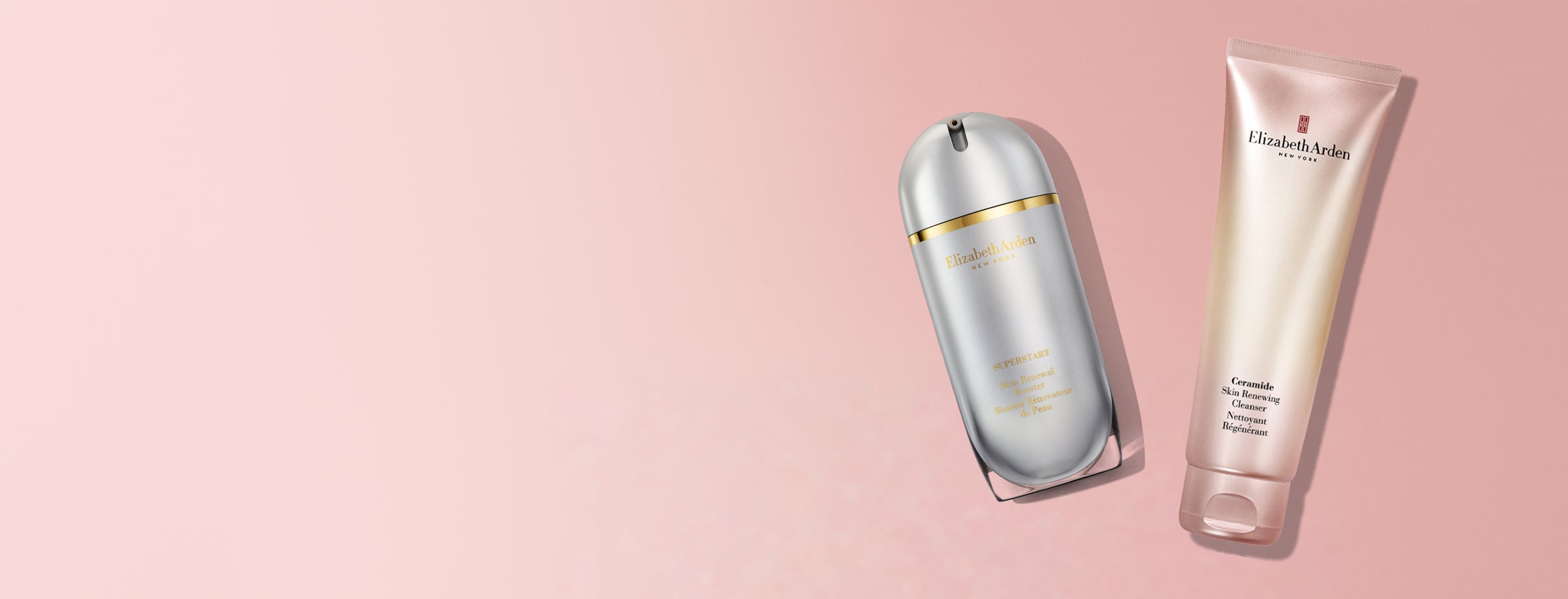 Elizabeth Arden skincare set featuring a Superstart Skin Renewal Booster, silver metallic bottle and Ceramide Skin Renewing Cleanser, a pink,yellow squeeze tube with gold accents, set against a solid pale pink background.