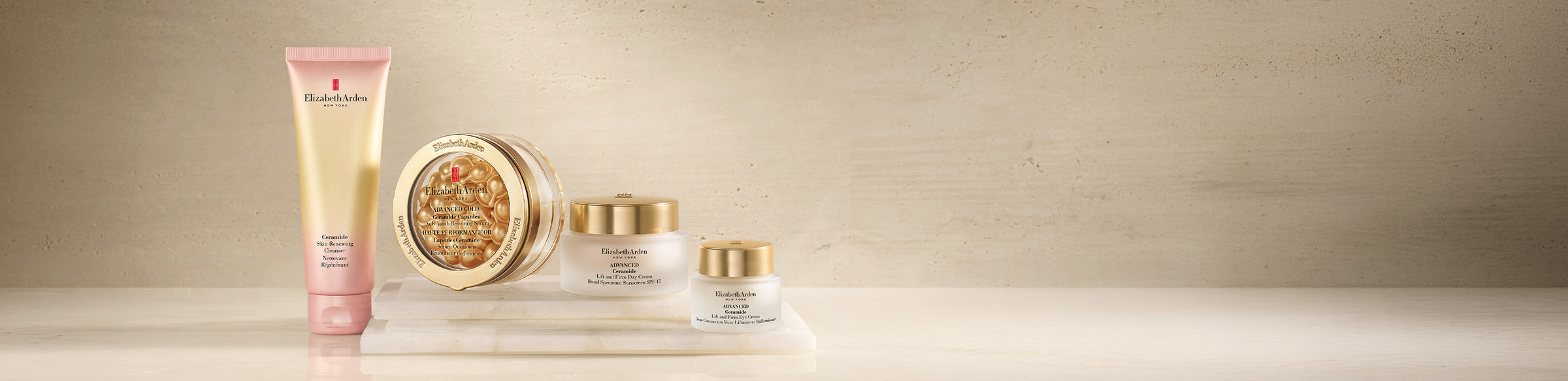Elizabeth Arden Ceramide Collection featuring a cleanser, capsules, moisturizer and eye cream on a beige textured background.