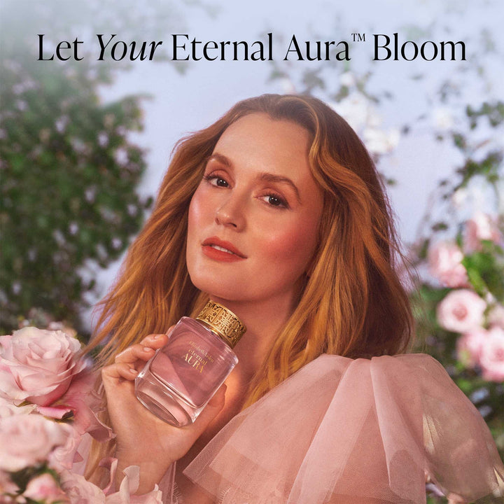 Leighton Meester, the brand embassador, is holding a perfume bottle with flowers in the background, featuring the text 'Let Your Eternal Aura™ Bloom'.