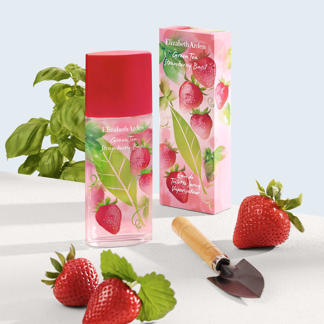 Green Tea Strawberry Basil Eau De Toilette with packaging, strawberries and basil.