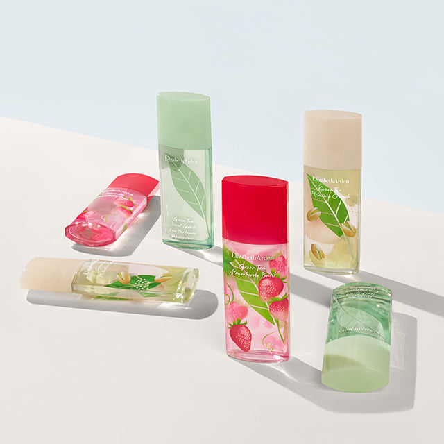 Green Tea fragrance bottles in original, pistachio, and strawberry basil scents styled on a light background.