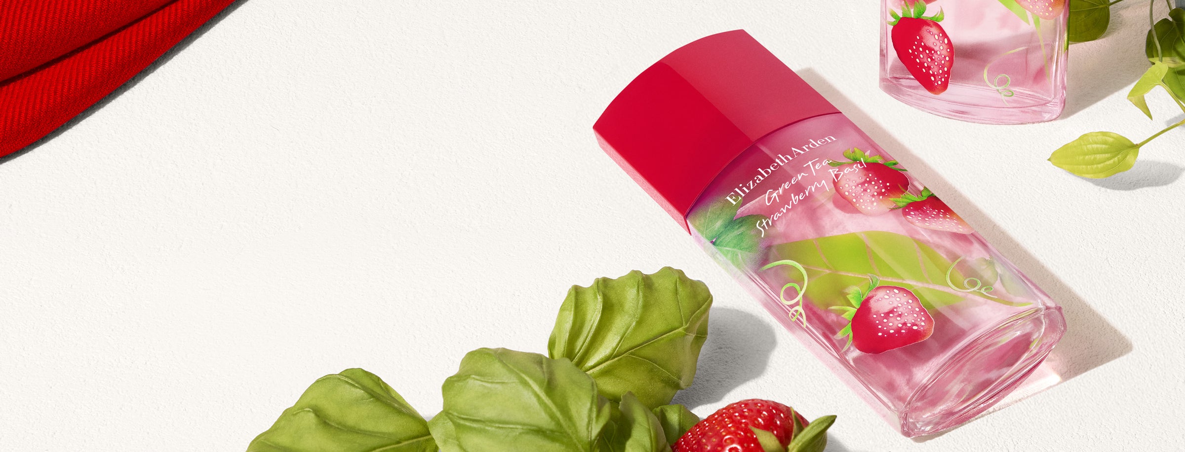 Elizabeth Arden Green Tea Strawberry Basil perfume bottle with strawberries and basil leaves on a light background