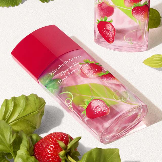 Elizabeth Arden Green Tea Strawberry Basil perfume bottle with strawberries and basil leaves on a light background