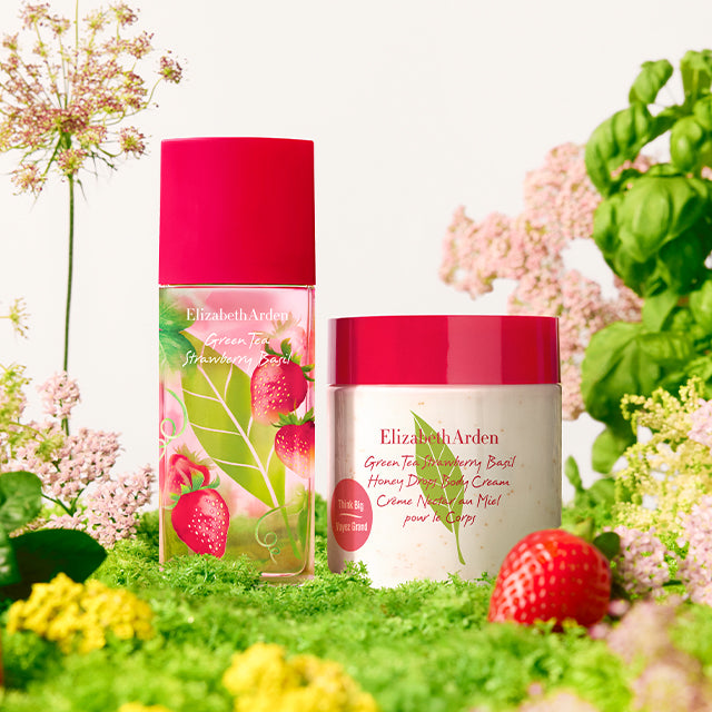 Green Tea Strawberry Basil Eau de Toilette and Honey Drops Body Cream in a cottage background with strawberries and basil. 
