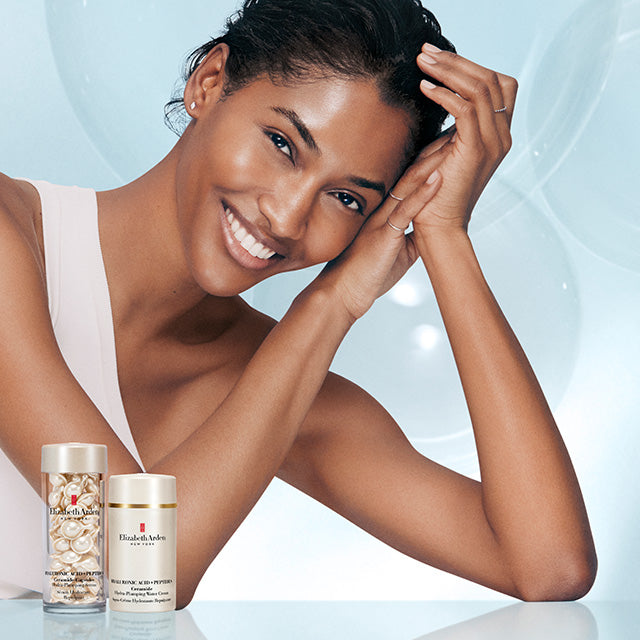 Woman with Hyaluronic Acid + Peptides Capsules and Water Cream on a light blue background