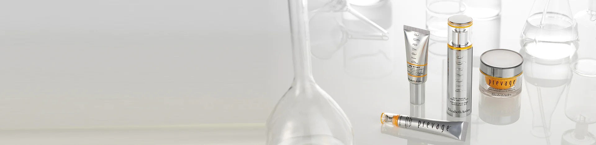 A set of products from the Prevage collection featured next to scientific tools on a greyish-white backround